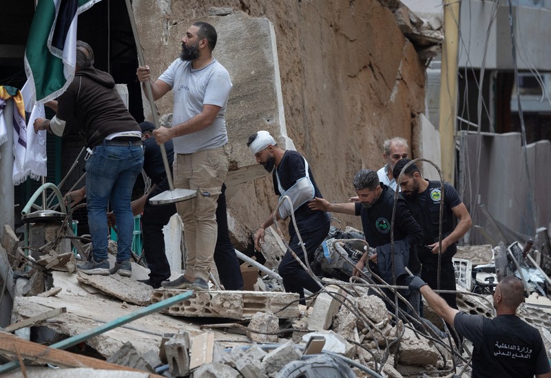 Orang-orang dan tim penyelamat berkumpul di lokasi serangan Israel terhadap sebuah gedung yang menurut sumber keamanan menewaskan kepala hubungan media Hizbullah Mohammad Afif di Ras Al-Nabaa, di Beirut, Lebanon, 17 November 2024. Orang-orang dan tim penyelamat berkumpul di lokasi serangan Israel terhadap sebuah gedung yang menurut sumber keamanan menewaskan kepala hubungan media Hizbullah Mohammad Afif di Ras Al-Nabaa, di Beirut, Lebanon, 17 November 2024. (REUTERS/Adnan Abidi)
