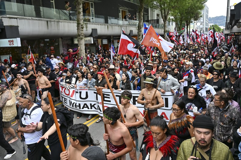 Anggota masyarakat Maori berpawai dalam aksi unjuk rasa untuk mengkritik pemerintah atas kebijakannya yang berdampak pada penduduk asli Maori di Wellington pada (19/11/2024). (AP Photo/Mark Tantrum) Anggota masyarakat Maori berpawai dalam aksi unjuk rasa untuk mengkritik pemerintah atas kebijakannya yang berdampak pada penduduk asli Maori di Wellington pada (19/11/2024). (AP Photo/Mark Tantrum)