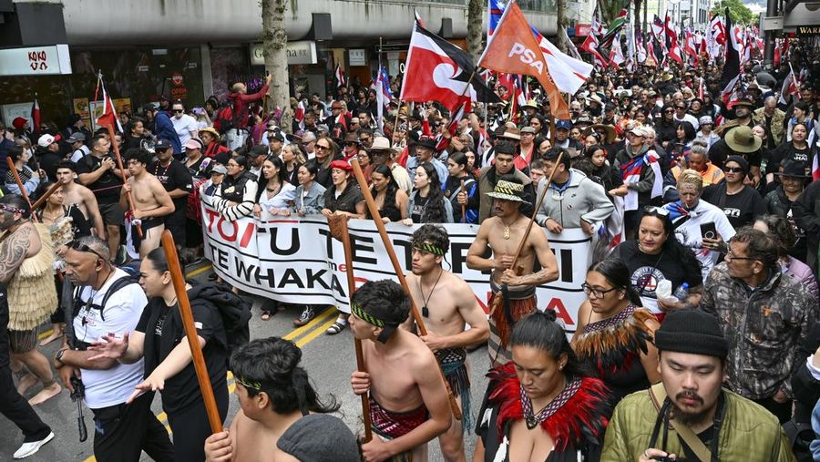Anggota masyarakat Maori berpawai dalam aksi unjuk rasa untuk mengkritik pemerintah atas kebijakannya yang berdampak pada penduduk asli Maori di Wellington pada (19/11/2024). (AP Photo/Mark Tantrum)