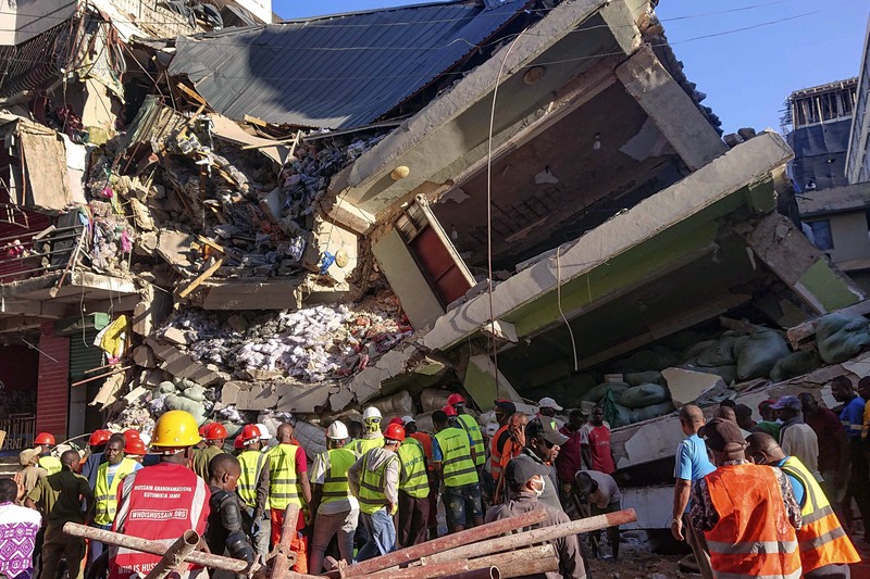 Orang-orang menghadiri lokasi bangunan yang runtuh di Dar es Salaam, Tanzania, Minggu, 17 November 2024. Orang-orang menghadiri lokasi bangunan yang runtuh di Dar es Salaam, Tanzania, Minggu, 17 November 2024. (AP Photo/Steven Genya)