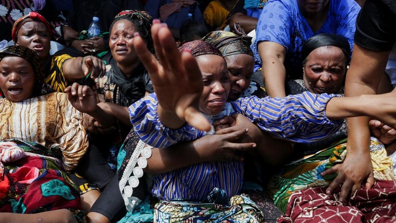 Orang-orang menghadiri lokasi bangunan yang runtuh di Dar es Salaam, Tanzania, Minggu, 17 November 2024. (AP Photo/Steven Genya)