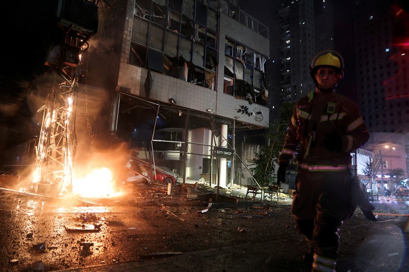 Petugas keamanan dan penyelamat bekerja di lokasi kejadian di mana sebuah bus dan bangunan terkena serangan roket dari Lebanon menuju Israel di Ramat Gan di Israel tengah, 18 November 2024. Petugas keamanan dan penyelamat bekerja di lokasi kejadian di mana sebuah bus dan bangunan terkena serangan roket dari Lebanon menuju Israel di Ramat Gan di Israel tengah, 18 November 2024. (REUTERS/Itai Ron)