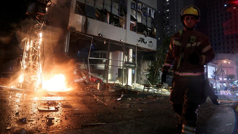 Petugas keamanan dan penyelamat bekerja di lokasi kejadian di mana sebuah bus dan bangunan terkena serangan roket dari Lebanon menuju Israel di Ramat Gan di Israel tengah, 18 November 2024. (REUTERS/Itai Ron)