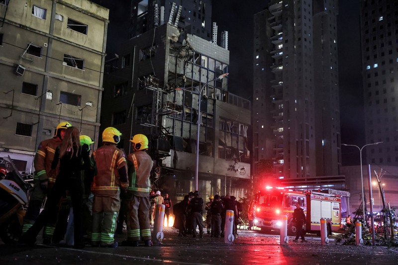 Petugas keamanan dan penyelamat bekerja di lokasi kejadian di mana sebuah bus dan bangunan terkena serangan roket dari Lebanon menuju Israel di Ramat Gan di Israel tengah, 18 November 2024. (REUTERS/Itai Ron)