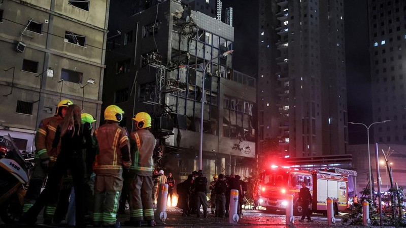 Petugas keamanan dan penyelamat bekerja di lokasi kejadian di mana sebuah bus dan bangunan terkena serangan roket dari Lebanon menuju Israel di Ramat Gan di Israel tengah, 18 November 2024. (REUTERS/Itai Ron)