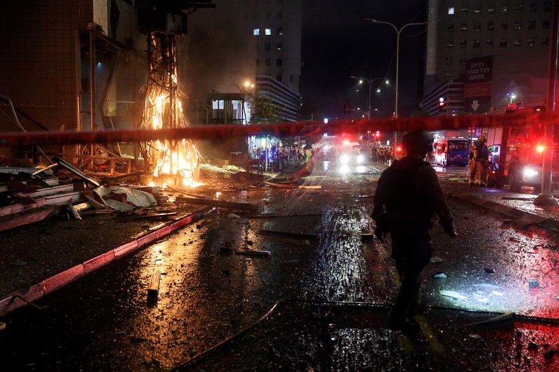 Petugas keamanan dan penyelamat bekerja di lokasi kejadian di mana sebuah bus dan bangunan terkena serangan roket dari Lebanon menuju Israel di Ramat Gan di Israel tengah, 18 November 2024. Petugas keamanan dan penyelamat bekerja di lokasi kejadian di mana sebuah bus dan bangunan terkena serangan roket dari Lebanon menuju Israel di Ramat Gan di Israel tengah, 18 November 2024. (REUTERS/Itai Ron)