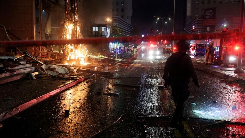 Petugas keamanan dan penyelamat bekerja di lokasi kejadian di mana sebuah bus dan bangunan terkena serangan roket dari Lebanon menuju Israel di Ramat Gan di Israel tengah, 18 November 2024. (REUTERS/Itai Ron)