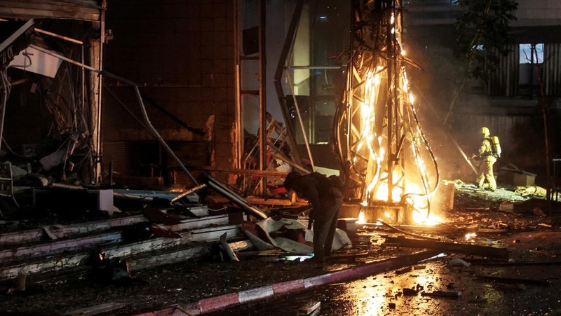 Petugas keamanan dan penyelamat bekerja di lokasi kejadian di mana sebuah bus dan bangunan terkena serangan roket dari Lebanon menuju Israel di Ramat Gan di Israel tengah, 18 November 2024. (REUTERS/Itai Ron)