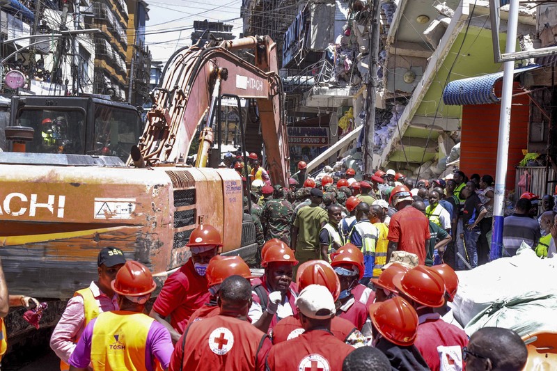 Orang-orang menghadiri lokasi bangunan yang runtuh di Dar es Salaam, Tanzania, Minggu, 17 November 2024. Orang-orang menghadiri lokasi bangunan yang runtuh di Dar es Salaam, Tanzania, Minggu, 17 November 2024. (AP Photo/Steven Genya)