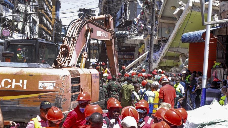 Orang-orang menghadiri lokasi bangunan yang runtuh di Dar es Salaam, Tanzania, Minggu, 17 November 2024. (AP Photo/Steven Genya)