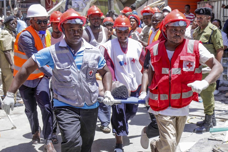 Orang-orang menghadiri lokasi bangunan yang runtuh di Dar es Salaam, Tanzania, Minggu, 17 November 2024. (AP Photo/Steven Genya)