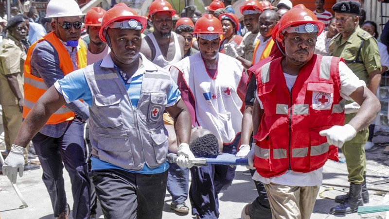 Orang-orang menghadiri lokasi bangunan yang runtuh di Dar es Salaam, Tanzania, Minggu, 17 November 2024. (AP Photo/Steven Genya)