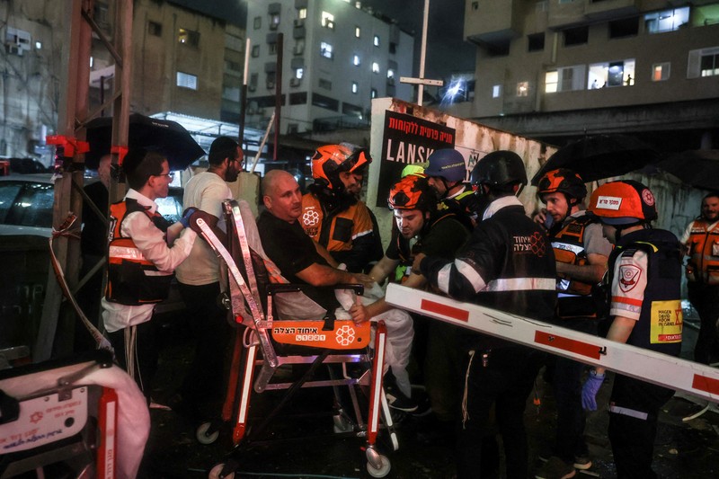 Petugas keamanan dan penyelamat bekerja di lokasi kejadian di mana sebuah bus dan bangunan terkena serangan roket dari Lebanon menuju Israel di Ramat Gan di Israel tengah, 18 November 2024. (REUTERS/Itai Ron)