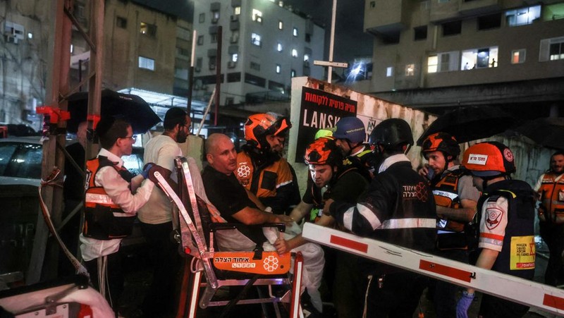 Petugas keamanan dan penyelamat bekerja di lokasi kejadian di mana sebuah bus dan bangunan terkena serangan roket dari Lebanon menuju Israel di Ramat Gan di Israel tengah, 18 November 2024. (REUTERS/Itai Ron)