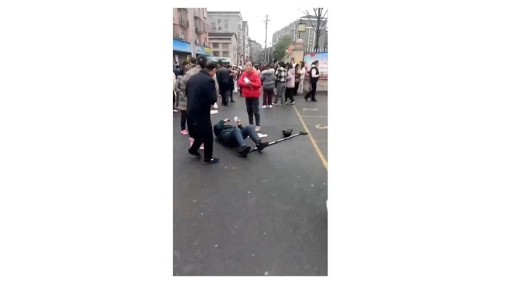 Seseorang tergeletak di tanah setelah tabrakan kendaraan di luar sekolah dasar di Changde, provinsi Hunan, Tiongkok dalam tangkapan layar yang diperoleh dari video media sosial, (19/11/2024). (Media Sosial/via REUTERS Beli Hak Lisensi)