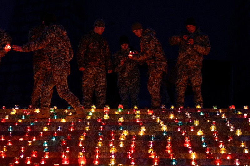 Warga Kota Kyiv, Ukraina, menggelar acara khusus untuk memperingati 1.000 hari sejak invasi besar-besaran Rusia dimulai pada 24 Februari 2022. Dalam peringatan ini, mereka menyalakan seribu lilin dan berdoa di depan Monumen Ibu Pertiwi. (REUTERS/Valentyn Ogirenko)