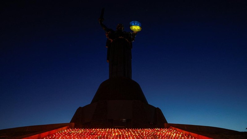 Warga Kota Kyiv, Ukraina, menggelar acara khusus untuk memperingati 1.000 hari sejak invasi besar-besaran Rusia dimulai pada 24 Februari 2022. Dalam peringatan ini, mereka menyalakan seribu lilin dan berdoa di depan Monumen Ibu Pertiwi. (REUTERS/Valentyn Ogirenko)