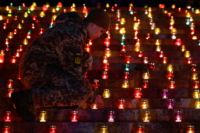 Warga Kota Kyiv, Ukraina, menggelar acara khusus untuk memperingati 1.000 hari sejak invasi besar-besaran Rusia dimulai pada 24 Februari 2022. Dalam peringatan ini, mereka menyalakan seribu lilin dan berdoa di depan Monumen Ibu Pertiwi. (REUTERS/Valentyn Ogirenko)