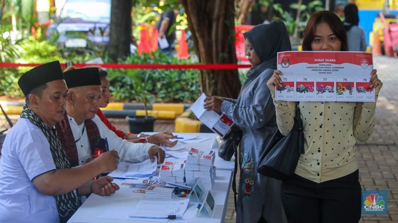 Warga menunjukkan surat suara saat Simulasi Pemungutan Suara dan Penghitungan Suara Pilkada Jakarta di Halaman Kantor Kecamatan Tanah Abang, Jakarta, Rabu (20/11/2024). (CNBC Indonesia/Faisal Rahman)