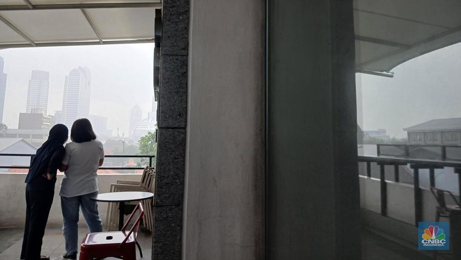 Pekerja mengamati curah hujan yang cukup deras di kawasan perkantoran wilayah Jakarta, Jumat (22/11/2024). (CNBC Indonesia/Tri Susilo)