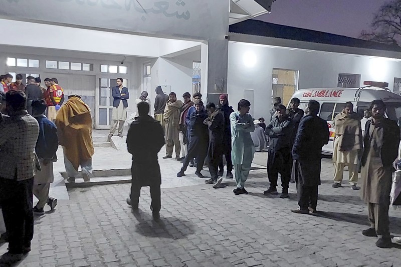 Seorang pelayat berdiri di samping jenazah para korban yang tewas dalam insiden penembakan oleh pria bersenjata, sebelum salat jenazah mereka, di Parachinar, kota utama distrik Kurram di provinsi Khyber Pakhtunkhwa, barat laut Pakistan, Jumat, 22 November 2024. (AP Photo/Hussain Ali)