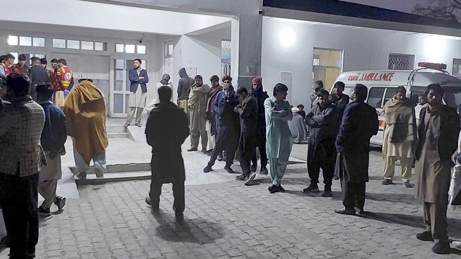 Seorang pelayat berdiri di samping jenazah para korban yang tewas dalam insiden penembakan oleh pria bersenjata, sebelum salat jenazah mereka, di Parachinar, kota utama distrik Kurram di provinsi Khyber Pakhtunkhwa, barat laut Pakistan, Jumat, 22 November 2024. (AP Photo/Hussain Ali)