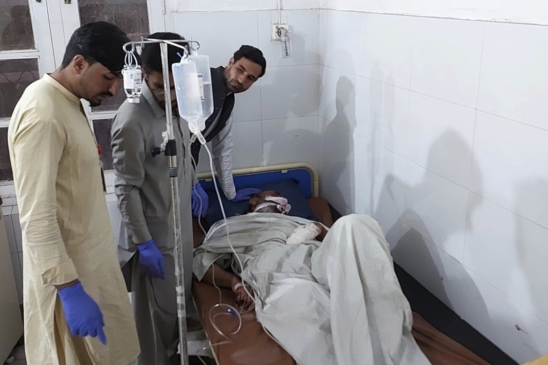 Seorang pelayat berdiri di samping jenazah para korban yang tewas dalam insiden penembakan oleh pria bersenjata, sebelum salat jenazah mereka, di Parachinar, kota utama distrik Kurram di provinsi Khyber Pakhtunkhwa, barat laut Pakistan, Jumat, 22 November 2024. (AP Photo/Hussain Ali)