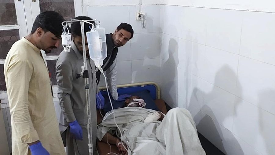 Seorang pelayat berdiri di samping jenazah para korban yang tewas dalam insiden penembakan oleh pria bersenjata, sebelum salat jenazah mereka, di Parachinar, kota utama distrik Kurram di provinsi Khyber Pakhtunkhwa, barat laut Pakistan, Jumat, 22 November 2024. (AP Photo/Hussain Ali)