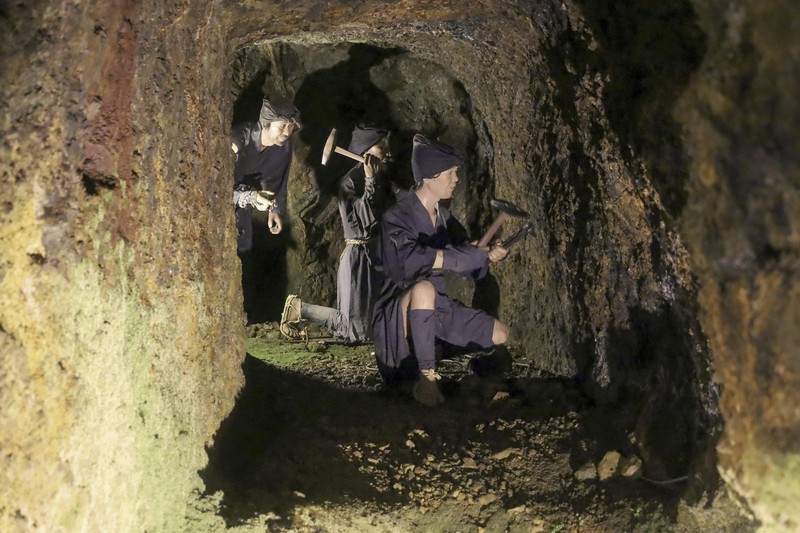 Guests offer a moment of silence during a memorial ceremony for the Sado Island Gold Mine in Sado, Niigata prefecture, Japan, Sunday, Nov. 24, 2024. (AP Photo/Eugene Hoshiko)