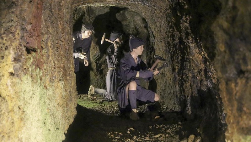 Guests offer a moment of silence during a memorial ceremony for the Sado Island Gold Mine in Sado, Niigata prefecture, Japan, Sunday, Nov. 24, 2024. (AP Photo/Eugene Hoshiko)