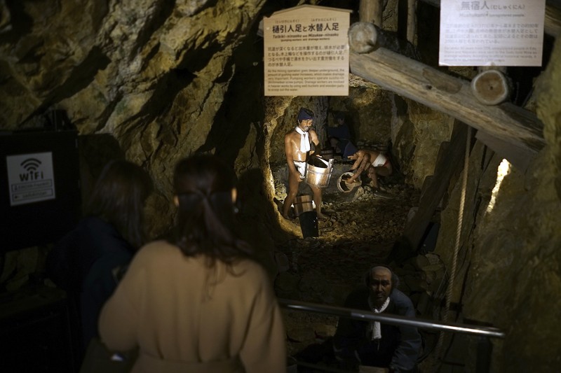 Guests offer a moment of silence during a memorial ceremony for the Sado Island Gold Mine in Sado, Niigata prefecture, Japan, Sunday, Nov. 24, 2024. (AP Photo/Eugene Hoshiko)