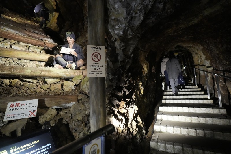 Guests offer a moment of silence during a memorial ceremony for the Sado Island Gold Mine in Sado, Niigata prefecture, Japan, Sunday, Nov. 24, 2024. (AP Photo/Eugene Hoshiko)