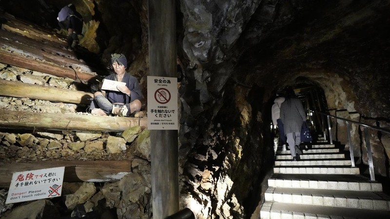 Guests offer a moment of silence during a memorial ceremony for the Sado Island Gold Mine in Sado, Niigata prefecture, Japan, Sunday, Nov. 24, 2024. (AP Photo/Eugene Hoshiko)