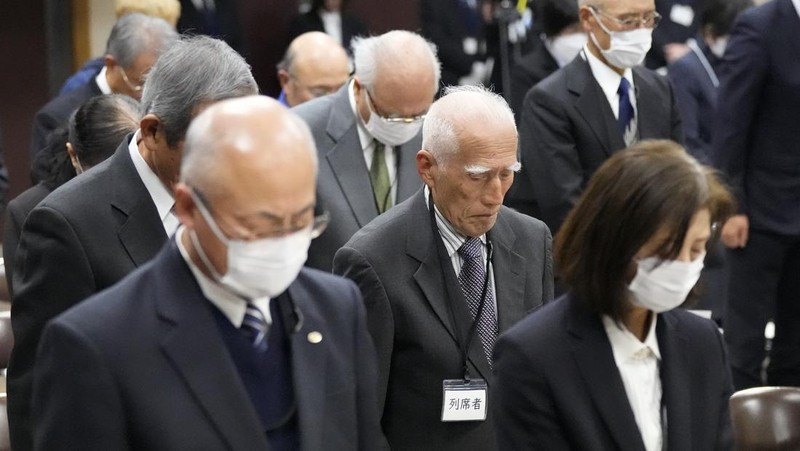 Guests offer a moment of silence during a memorial ceremony for the Sado Island Gold Mine in Sado, Niigata prefecture, Japan, Sunday, Nov. 24, 2024. (AP Photo/Eugene Hoshiko)