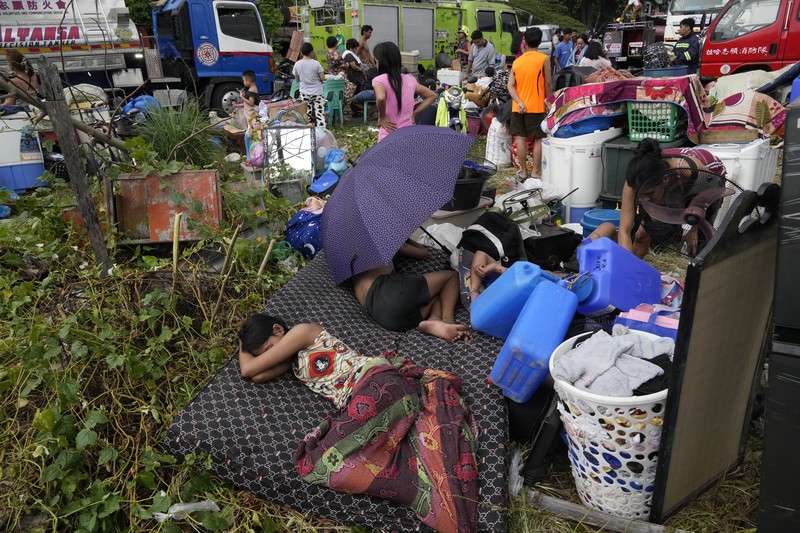 A Philippine Air Force helicopter drops water on burning homes as fire broke out at a slum area leaving about 2,000 families homeless on Sunday, Nov. 24, 2024 in Manila, Philippines. (AP Photo/Aaron Favila)
