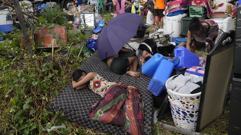 A Philippine Air Force helicopter drops water on burning homes as fire broke out at a slum area leaving about 2,000 families homeless on Sunday, Nov. 24, 2024 in Manila, Philippines. (AP Photo/Aaron Favila)