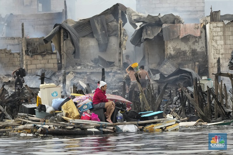 A Philippine Air Force helicopter drops water on burning homes as fire broke out at a slum area leaving about 2,000 families homeless on Sunday, Nov. 24, 2024 in Manila, Philippines. (AP Photo/Aaron Favila)