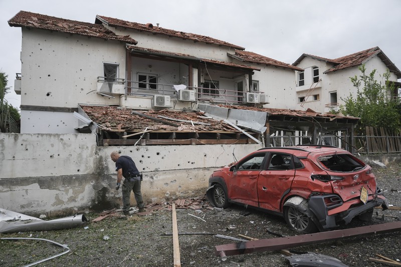 ISRAEL-PALESTINIANS/LEBANON People check their family's damaged house at the scene where one of the projectiles fell, after projectiles crossed over to Israel from Lebanon, amid ongoing hostilities between Hezbollah and Israel, in Rinatiya, Israel, November 24, 2024. REUTERS/Itai Ron ISRAEL OUT. NO COMMERCIAL OR EDITORIAL SALES IN ISRAEL REFILE - CORRECTING