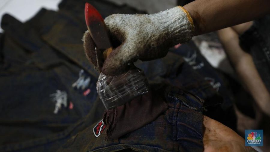 Pekerja menyelesaikan pencucian pakaian jeans di kawasan Jakarta,  Senin (25/11/2024). Pemerintah bakal memberlakukan tarif Pajak Pertambahan Nilai (PPN) sebesar 12% di tahun 2025 nanti. (վ/Tri Susilo)