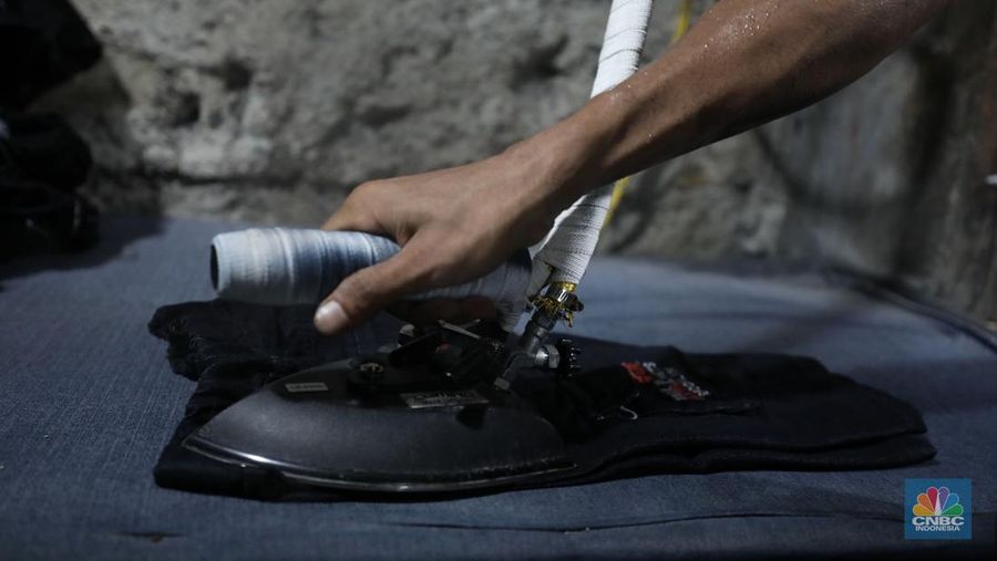Pekerja menyelesaikan pencucian pakaian jeans di kawasan Jakarta,  Senin (25/11/2024). Pemerintah bakal memberlakukan tarif Pajak Pertambahan Nilai (PPN) sebesar 12% di tahun 2025 nanti. (վ/Tri Susilo)