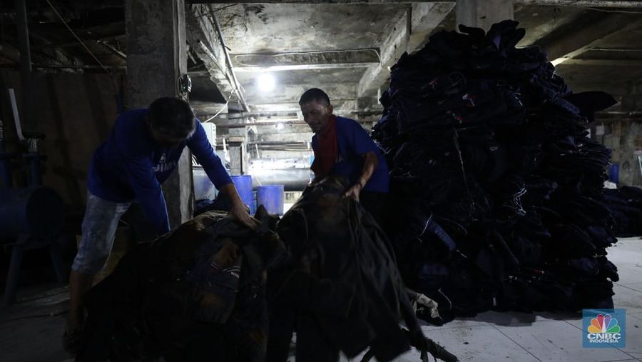 Pekerja menyelesaikan pencucian pakaian jeans di kawasan Jakarta,  Senin (25/11/2024). Pemerintah bakal memberlakukan tarif Pajak Pertambahan Nilai (PPN) sebesar 12% di tahun 2025 nanti. (վ/Tri Susilo)