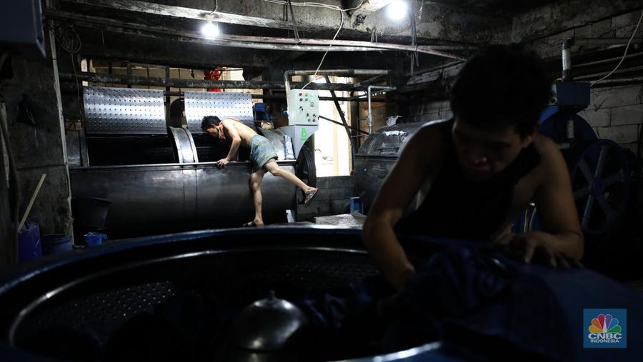Pekerja menyelesaikan pencucian pakaian jeans di kawasan Jakarta,  Senin (25/11/2024). Pemerintah bakal memberlakukan tarif Pajak Pertambahan Nilai (PPN) sebesar 12% di tahun 2025 nanti. (վ/Tri Susilo)