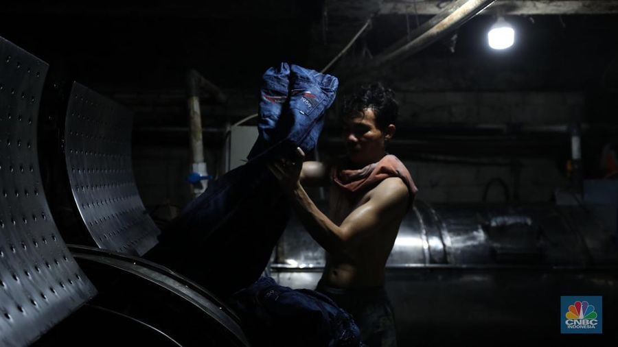 Pekerja menyelesaikan pencucian pakaian jeans di kawasan Jakarta,  Senin (25/11/2024). Pemerintah bakal memberlakukan tarif Pajak Pertambahan Nilai (PPN) sebesar 12% di tahun 2025 nanti. (վ/Tri Susilo)