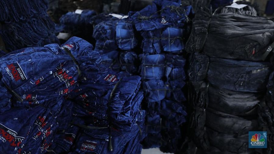Pekerja menyelesaikan pencucian pakaian jeans di kawasan Jakarta,  Senin (25/11/2024). Pemerintah bakal memberlakukan tarif Pajak Pertambahan Nilai (PPN) sebesar 12% di tahun 2025 nanti. (վ/Tri Susilo)