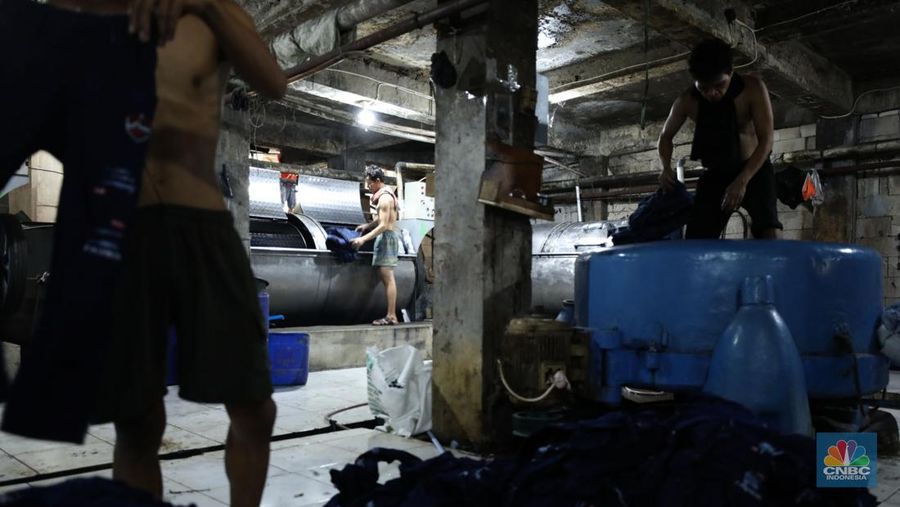 Pekerja menyelesaikan pencucian pakaian jeans di kawasan Jakarta,  Senin (25/11/2024). Pemerintah bakal memberlakukan tarif Pajak Pertambahan Nilai (PPN) sebesar 12% di tahun 2025 nanti. (վ/Tri Susilo)