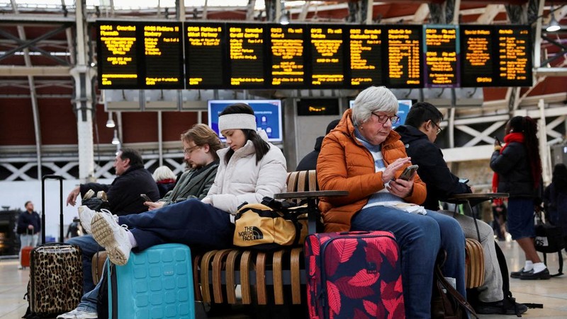 Penumpang kereta api menunggu dengan barang bawaan mereka setelah pembatalan kereta yang disebabkan oleh Badai Bert, di Stasiun Paddington di London, Inggris, 25 November 2024. (REUTERS/Mina Kim)