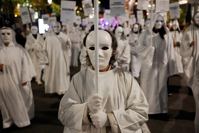 Para demonstran membawa spanduk berisi nama-nama korban kekerasan berbasis gender selama aksi protes untuk memperingati Hari Internasional untuk Penghapusan Kekerasan terhadap Perempuan di Madrid, Spanyol, 25 November 2024. (REUTERS/Susana Vera)