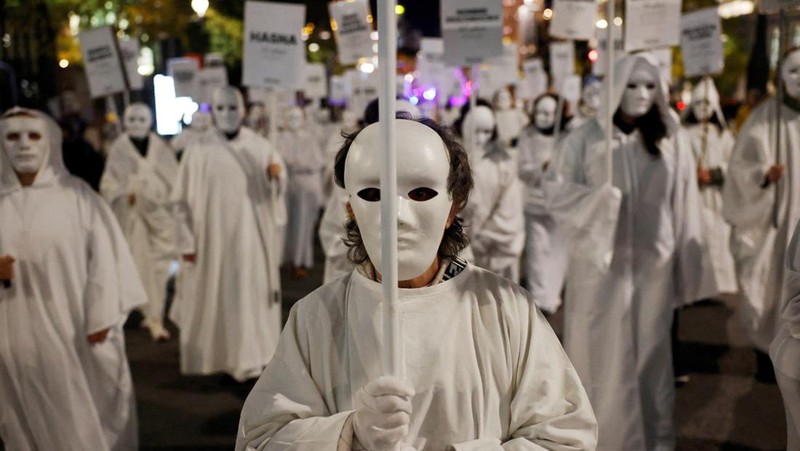 Para demonstran membawa spanduk berisi nama-nama korban kekerasan berbasis gender selama aksi protes untuk memperingati Hari Internasional untuk Penghapusan Kekerasan terhadap Perempuan di Madrid, Spanyol, 25 November 2024. (REUTERS/Susana Vera)