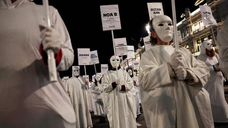 Para demonstran membawa spanduk berisi nama-nama korban kekerasan berbasis gender selama aksi protes untuk memperingati Hari Internasional untuk Penghapusan Kekerasan terhadap Perempuan di Madrid, Spanyol, 25 November 2024. (REUTERS/Susana Vera)