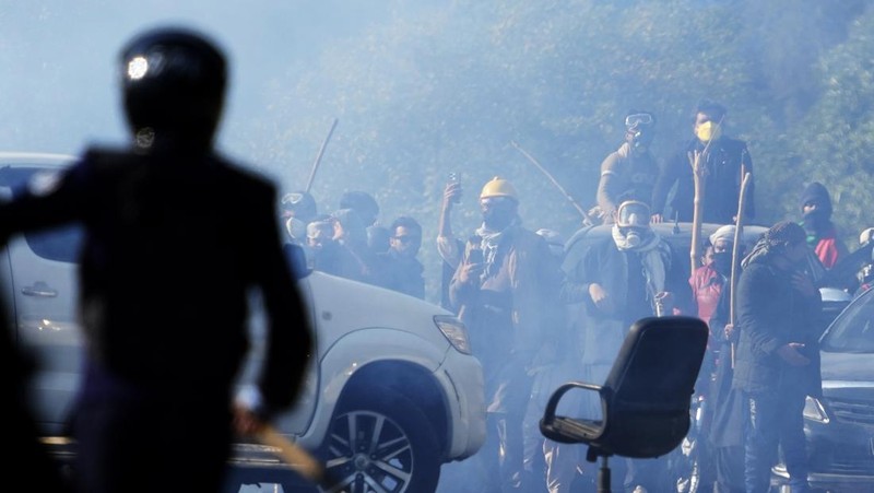 Pendukung mantan Perdana Menteri Imran Khan dari partai Tehreek-e-Insaf Pakistan yang dipenjara melemparkan batu ke arah polisi selama bentrokan di Islamabad, Pakistan, Selasa, 26 November 2024. (AP Photo/Anjum Naveed)